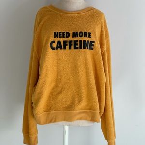 Yellow sweatshirt with “need more caffeine”